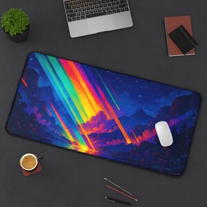 May include: A rectangular desk mat featuring a vibrant, colorful landscape design. The artwork depicts a night sky with a rainbow of light streaks, clouds, and mountains. A white computer mouse rests on the mat.