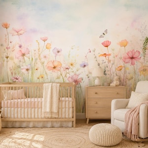 Könnte beinhalten: Ein Kinderzimmer mit einem hellen Holzbett, einer Kommode und einem Sessel. Die Wand zeigt ein Blumenwandbild in Pastelltönen. Ein geflochtener Korb enthält ein Stoffkaninchen. Ein runder Jute-Teppich und ein gestrickter Hocker vervollständigen den Raum.