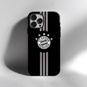 May include: Black phone case with a vertical stripe design in gray and white. The case features the FC Bayern Munich logo in the center. The phone case is designed to fit a smartphone.