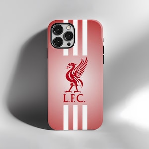 May include: A red and white phone case featuring the Liverpool Football Club emblem. The case has a gradient background with vertical white stripes. The team's crest, a red Liver bird, is centered below the camera lenses, with "L.F.C." below.