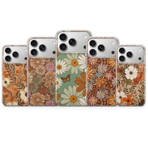 May include: Five smartphone cases arranged in a row, each featuring a distinct floral pattern in earthy tones of orange, brown, cream, and sage green. The designs include various flower types, leaves, and a small butterfly on the center case.