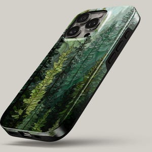 May include: A smartphone case featuring a detailed forest print with various shades of green, including dark pine and bright lime foliage. The case has a black frame, cutouts for the camera lenses, and side buttons visible on the right edge.