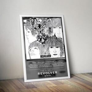 May include: A framed black and white poster featuring the Beatles' album "Revolver." The artwork includes portraits of the band members and the album title. The poster also lists the song titles from the album.