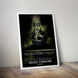 Puede incluir: Un póster enmarcado con una representación artística oscura de una calavera coronada con una estructura similar a un castillo. El póster muestra el texto "THE DEVIL WEARS PRADA DEAD THRONE" y una lista de títulos de canciones. La paleta de colores es principalmente negra, verde y blanca.
