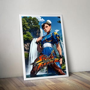 May include: A framed print featuring a character from Street Fighter. The artwork depicts a woman in a blue and white outfit, standing in front of a waterfall. The Street Fighter logo is prominently displayed.