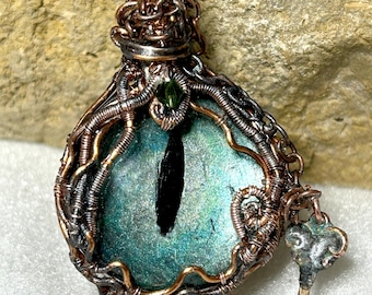 Collar colgante amuleto de ojo verde de dragón mítico, cabujón de vidrio pintado a mano, envuelto en alambre de cobre.