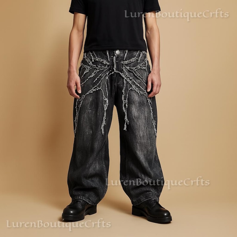 May include: Black denim jeans with a distinctive distressed design. The jeans have a wide leg and a decorative pattern of frayed fabric. The text "LurenBoutiqueCrfts" is visible in the image.