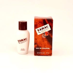 May include: A white Tabac Original Eau de Cologne bottle with a dark brown cap and matching text, next to a brown box. The box features the Tabac Original logo and text, including "EAU DE COLOGNE" and "4 ml".