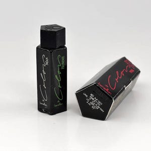 May include: Two black perfume bottles with the text "Colors" and "Man" and "Homme" in green and white. The box next to the bottle has the text "Colors" in red.