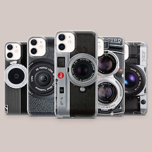 May include: A collection of five phone cases featuring vintage camera lens designs. Each case showcases a different camera lens, with details like the lens name, aperture, and brand logos. The cases are clear, allowing the phone's color to show through.
