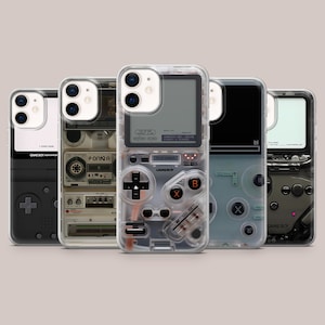 Puede incluir: Una colección de fundas transparentes para teléfonos con diseños de consolas de videojuegos retro. Las fundas presentan varios diseños de botones, pantallas y texto, incluyendo "GAME BOY" y "START GAME". Las fundas están diseñadas para un smartphone y ofrecen una estética nostálgica.