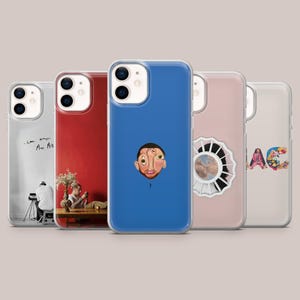 Könnte beinhalten: Eine Sammlung von fünf Handyhüllen mit verschiedenen Designs. Die Hüllen haben eine Reihe von Farben, darunter Rot und Blau. Einige Hüllen zeigen Albumcover und Porträts. Die Hüllen sind für ein Smartphone konzipiert.