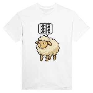 Pode incluir: Camiseta branca com uma ilustração de ovelha de desenho animado. A ovelha tem os olhos fechados e uma bolha de pensamento acima. A bolha de pensamento diz "UNTZ" três vezes. A ovelha é bege com pernas e cascos marrons.
