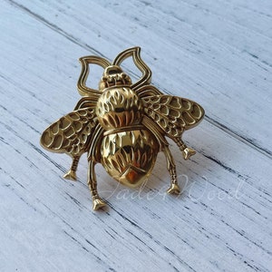 Könnte beinhalten: Ein goldfarbener Türknauf in Bienenform mit filigranen Details. Der Knauf ist aus Metall und hat ein realistisches Bienendesign.