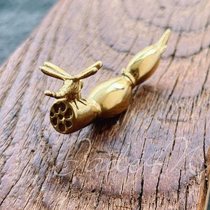 May include: Gold-toned metal dragonfly figurine with a detailed design. The dragonfly is perched on a long, slender, gold-toned metal rod.