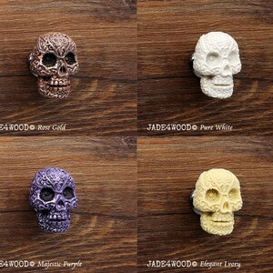 May include: Four decorative skull drawer pulls in different colors: rose gold, pure white, majestic purple, and elegant ivory. Each skull has intricate details and a floral design.