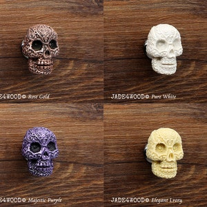 May include: Four decorative skull drawer pulls in different colors: rose gold, pure white, majestic purple, and elegant ivory. Each skull has intricate details and a floral design.