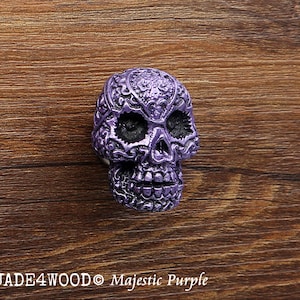 May include: Purple skull-shaped cabinet knob with intricate floral designs.  JADE4WOOD Majestic Purple.
