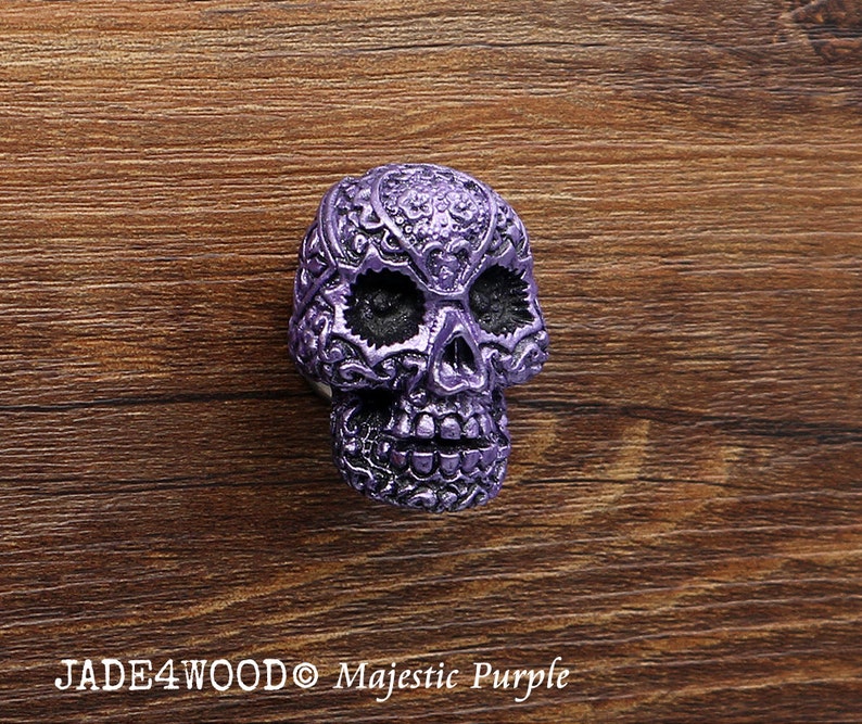 May include: Purple skull-shaped cabinet knob with intricate floral designs.  JADE4WOOD Majestic Purple.