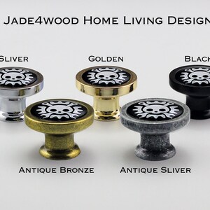 May include: Five cabinet knobs with a skull and crossbones design. The knobs are in silver, golden, black, antique bronze, and antique silver.