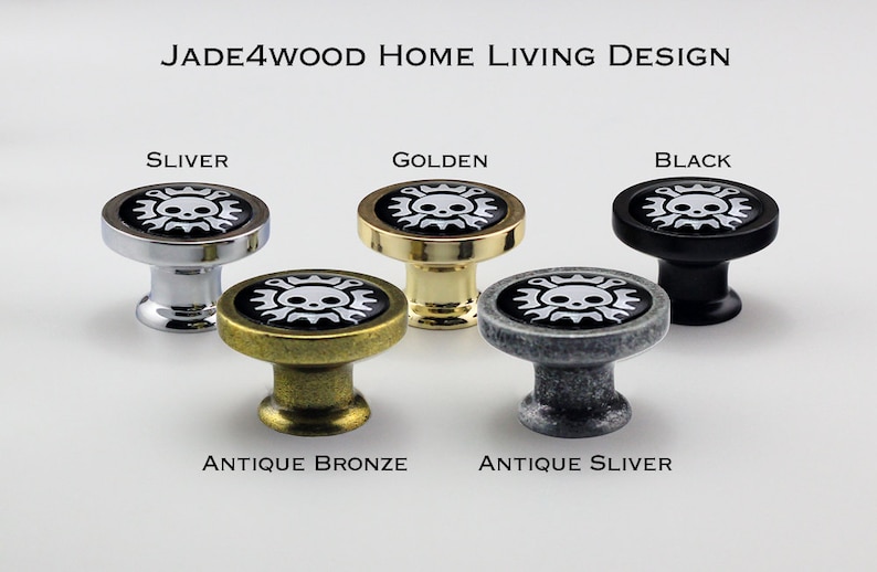 May include: Five cabinet knobs with a skull and crossbones design. The knobs are in silver, golden, black, antique bronze, and antique silver.