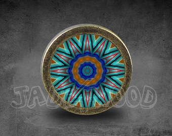 Può includere: Un pomello rotondo color ottone con un design geometrico colorato. Il design presenta un motivo a mandala blu, arancione e rosso.