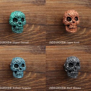 May include: Four decorative skull drawer pulls in different colors: elegant emerald, copper kettle, brilliant turquoise, and black shimmer. Each skull has intricate details and a unique finish.