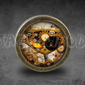 May include: A round, brass-colored pendant with a glass insert featuring a steampunk-style cat design. The cat's eyes are glowing orange, and the design is made up of gears, cogs, and other mechanical elements.