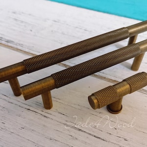 Pode incluir: Três puxadores de armário de latão antigo com acabamento texturizado. Os puxadores medem 12,7 cm de comprimento e têm um design simples. Os puxadores são perfeitos para adicionar um toque de estilo vintage a qualquer casa.