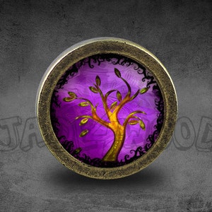 Könnte beinhalten: Ein runder, bronzefarbener Anhänger mit einem violetten und goldenen Lebensbaum-Design. Der Baum ist von einem schwarzen, wirbelnden Rand umgeben.