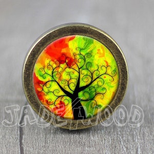 Puede incluir: Un pomo redondo de color latón con un diseño de árbol de la vida colorido. El árbol está pintado en tonos de rojo, amarillo y verde, con una silueta negra.