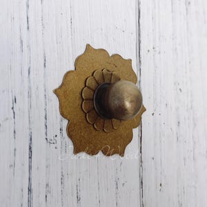 May include: A white ceramic mug with a black handle and the text "But first, coffee" in a black, handwritten-style font. The mug is on a white surface.