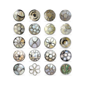 May include: Twenty decorative buttons with inlaid designs. The buttons display diverse patterns, including geometric shapes and floral motifs, with iridescent and metallic accents. Each button is a unique design, suitable for various crafts.