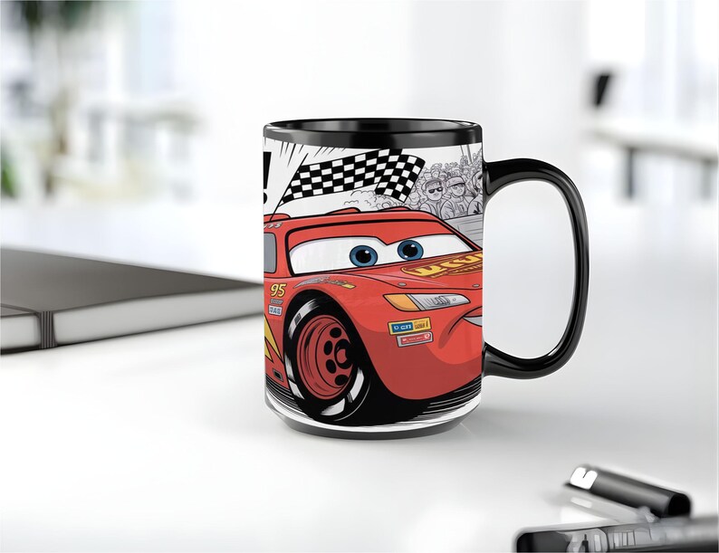 K&ouml;nnte beinhalten: Ein schwarzer Keramikbecher mit einer grafischen Illustration eines roten Rennwagens mit der Nummer 95 an der Seite. Das Design zeigt eine Zielflagge, eine Zuschauermenge sowie die blauen Augen und den l&auml;chelnden Mund des Autos.