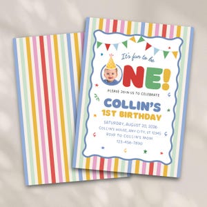 May include: A first birthday invitation card featuring a colorful vertical striped border. The text reads: It's fun to be ONE! PLEASE JOIN US TO CELEBRATE COLLIN'S 1ST BIRTHDAY SATURDAY, AUGUST 20, 2026 COLLIN'S HOUSE, ANY CITY, ST 12345 RSVP TO COLLIN'S MOM 123-456-7890.
