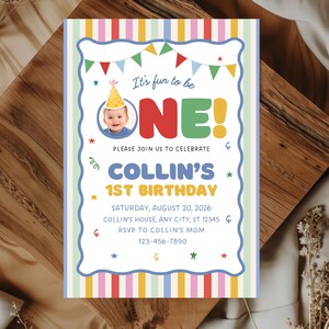 May include: A rectangular birthday invitation card featuring a colorful striped border and a scalloped white center. The text reads: It's fun to be ONE! PLEASE JOIN US TO CELEBRATE COLLIN'S 1ST BIRTHDAY SATURDAY, AUGUST 20, 2026 COLLIN'S HOUSE, ANY CITY, ST 12345 RSVP TO COLLIN'S MOM 123-456-7890.