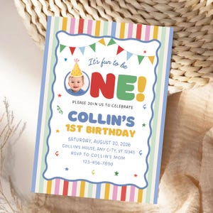May include: A rectangular birthday invitation card featuring a colorful vertical striped border and a white center panel. The text reads: It's fun to be ONE! PLEASE JOIN US TO CELEBRATE COLLIN'S 1ST BIRTHDAY SATURDAY, AUGUST 20, 2026, COLLIN'S HOUSE, ANY CITY, ST 12345, RSVP TO COLLIN'S MOM 123-456-7890.