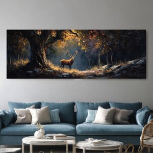 May include: A large rectangular canvas print depicting a majestic deer in a forest setting. The artwork features a brown deer with large antlers standing in a clearing, surrounded by trees with autumn foliage. The color palette includes shades of brown, gold, and dark green.