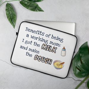 May include: A white laptop sleeve with a black border. The sleeve features the text "Benefits of being a working mom: I got the MILK and make the DOUGH" with illustrations of a baby bottle and a bowl with a whisk.