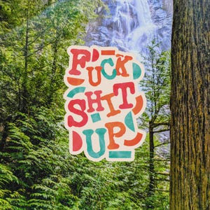 May include: A sticker featuring the phrase "F*ck Shit Up" in a retro font, with a green, orange, and red colour scheme. The background shows a forest and a waterfall.