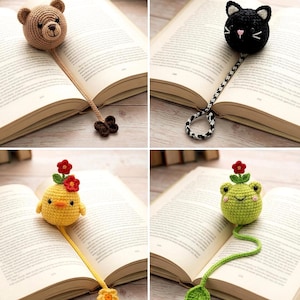 May include: Four handmade crochet bookmarks. The bookmarks feature a brown bear, a black cat, a yellow chick, and a green frog. Each bookmark is attached to a long cord and placed in an open book. The bear, chick, and frog have flower accents.