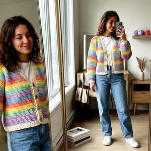 Könnte beinhalten: Ein regenbogenfarbener, gehäkelter Cardigan mit cremefarbenem Besatz und Holzknöpfen. Der Pullover wird mit einem weißen T-Shirt und einer blauen Jeans getragen. Die Farben des Cardigans sind Rot, Orange, Gelb, Grün, Blau und Lila.