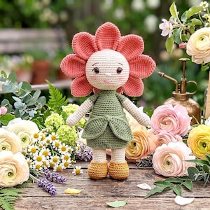 May include: A handmade crochet doll in the shape of a flower. The doll has a peach-colored flower head, a light green dress, and yellow shoes. The doll is standing on a wooden surface surrounded by flowers.