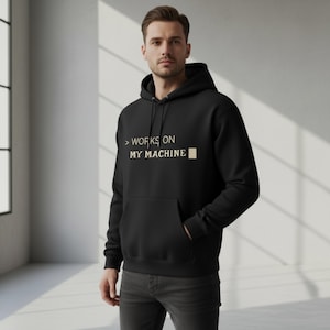 Può includere: Felpa con cappuccio nera con tasca frontale e coulisse. Il testo "> WORKS ON MY MACHINE" è stampato in beige chiaro. Questa felpa con cappuccio casual è realizzata in un materiale morbido ed è adatta all'uso quotidiano.