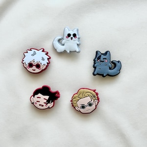 May include: A set of three ceramic mugs with a speckled, matte finish. The mugs are in shades of cream, light gray, and dark gray. Each mug has a simple, minimalist design and a rounded handle. The mugs are likely for coffee or tea.