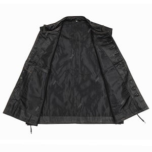 May include: Open view of a black leather jacket with a button-up front. The jacket has a classic design with a notched collar, multiple pockets, and a full lining. The leather appears worn, giving it a vintage look. The jacket is unbuttoned, revealing the interior.