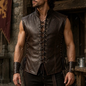 May include: A dark brown sleeveless vest featuring a high collar and a front lace-up closure with metal eyelets. The vest is paired with matching dark brown leather wrist cuffs that have a textured surface and a circular metal button detail.