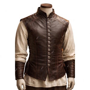 May include: A brown leather vest with a high collar and silver buttons. The vest has a fitted design and is worn over a cream-colored long-sleeved shirt. The sleeves have brown leather cuffs. The vest is displayed on a mannequin.