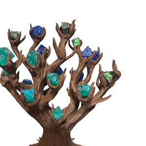 Puede incluir: Un soporte para dados en forma de &aacute;rbol marr&oacute;n con m&uacute;ltiples ramas, cada una de las cuales sostiene un dado de diferente color. Los dados son de varios colores, incluyendo azul, verde y transparente. El soporte est&aacute; dise&ntilde;ado para exhibir y guardar dados.