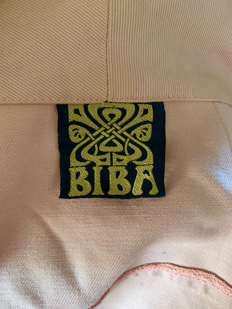 May include: A close-up of a black label with a gold design and the word "BIBa" in gold lettering.